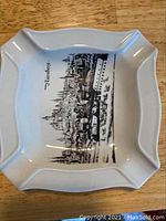 Top view of a white square porcelain ashtray featuring black cityscape design labeled 'Turnberry'