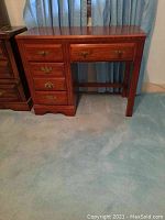 Full view of Broyhill wooden desk with multiple drawers and brass handles showing overall condition and size.