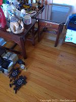 Two wooden end tables seen with various items on and around them demonstrating their typical size and design, showing polished dark wood with drawers and metal handles.