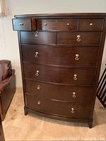 Full front view of Kincaid wooden dresser showing multiple drawers with metallic ring handles