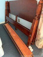 Disassembled king size four poster bed's headboard and footboard with decorative carved posts.