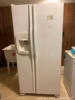 Front view of Maytag side-by-side refrigerator white finish with two vertical doors and external water and ice dispenser on the left door.