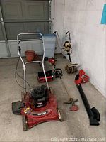 Wide shot showing all items in the lot including lawn mower, power shovel, weed eater, roto tiller, power blower, trash can, and pots.