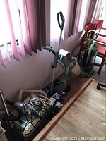 Overview photo showing Kenmore canister vacuum with attached hose and a Regina carpet steamer next to a green upright vacuum.