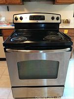 Front view of GE electric oven showing entire appliance with stainless steel finish and four coil burners.