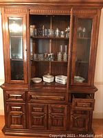 Full view of vintage wooden cabinet with Corning Ware and assorted glassware inside
