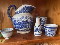 Front view of 7 blue and white porcelain decorative pieces including pitcher, vases, and bowls, showing their pattern and condition.