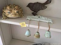 Photo showing the toad figurine, metal bird, and garden chimes with hanging bells