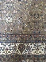 Close-up of rug field showing floral and arabesque pattern on grey-taupe ground with rust and turquoise accents