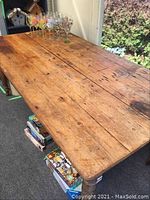 Full view of the wooden tabletop showing plank construction, knots and general wear.