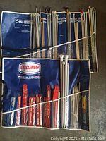 Full view of knitting needle organizers with numerous knitting needles and knitting accessories, showing chalk size labels and organized sections.