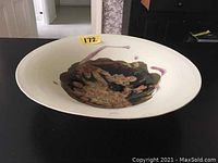 Shallow overhead view of bowl showing off-white exterior and interior abstract glaze.