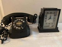 Front view of black Bakelite rotary telephone and Hammond electric clock side by side