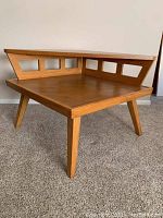 Front three-quarter view showing square lower shelf, triangular upper shelf, splayed legs