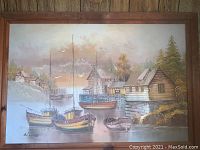 Framed original painting depicting boats docked in a harbor with wooden houses in the background.