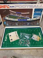 Full set including playing field, player pieces in bags, and original manuals, all arranged inside the game box showing the complete contents.