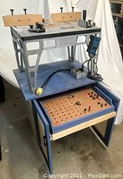 Front view of complete router table setup mounted on blue wheeled cabinet with roll-out bit drawer