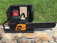 Poulan Pro PP4218A chainsaw inside black plastic carrying case along with extra chain in packaging and manual