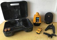 Image of the Pro Shot L5 laser level with the case and accessories laid out on a surface including batteries and mounts.