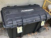 Closed Husky 37 inch rolling tool box with visible metal latches and wheels