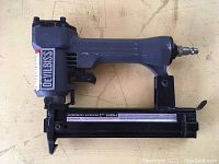 Full side view of DeVilbiss SHBN4 pneumatic finish nailer showing overall condition and nail magazine.