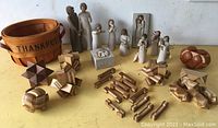 Full lot photo showing wood puzzles in front, Willow Tree angel figurines behind, Shaker-style basket on left, small wooden treasure chest on right.