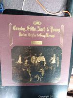 Front cover of the vinyl LP album 'Deja Vu' by Crosby, Stills, Nash & Young with Dallas Taylor and Greg Reeves featuring brown gatefold sleeve with gold text and sepia band photo.