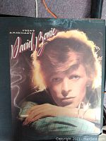 Front cover of the 'Young Americans' album by David Bowie showing cover art with Bowie's portrait and album title in script.