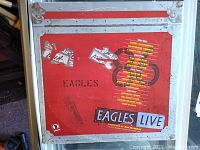 Red flight case with Eagles Live and tracklist from 1980 tour with stickers and wear visible