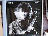Front cover of Jimmy Page Outrider vinyl record album showing artistic black and white image of artist holding guitar