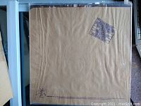 Brown kraft paper bag cover laid flat showing a rectangular boxed patent number stamp.