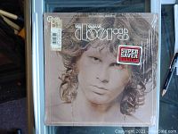 Front cover of The Best of Doors 1973 Electra Records vinyl album featuring Jim Morrison portrait and stickers.