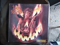 Vinyl record album cover of The Fastway 'Trick or Treat' showing person with guitar amid flames forming a jack-o'-lantern face, image focused on front cover artwork.
