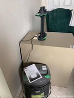 Paper shredder showing top control panel and manual booklet on top of shredder.