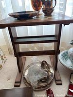 Side angle view of wooden chess table showing the pedestal base and lower support shelf.