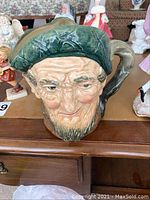 Front view of Royal Doulton Toby jug character mug showing detailed facial features and green cap.