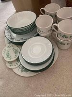 Photo showing complete set of Corelle dishes including plates, bowls, mugs, and small dishes arranged together.