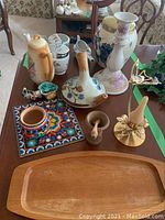 Top-view of table displaying the Delft canister, mini teapot, sauce boats, Huichol beaded souvenirs, candle holders, wood tray, and wooden containers