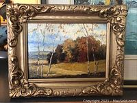 Frontal photo of the oil painting showing autumn landscape with birch trees and ornate gold frame