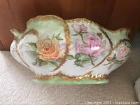 Side view of the French porcelain bowl showing yellow and pink rose designs with gold accents.
