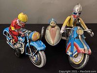 Front view of both tin wind-up motorcycles and sidecar showing painted riders and detailed design.