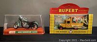 Guiloy Harley Davidson die-cast motorcycle model and Rupert Collectibles 1928 Chevrolet box van side by side in original packaging.