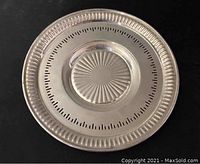 Top-down view of round sterling silver plate on black background