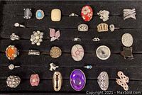 Full display of assortment of vintage costume rings, approximately 30 pieces showing diverse styles, colors, and stones.