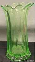 Front angle view of antique green Vaseline glass vase, showing color and ruffled top