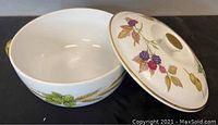 Lidded white casserole dish with painted fruit and leaves design on the lid and outside.