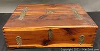 Closed top view of vintage cedar dovetail keepsake chest showing brass accents and lock plate on lid.