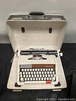 Majestic 812 typewriter inside open hard carrying case showing overall condition and case interior.