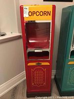 Front view of red and yellow popcorn machine with glass front panel