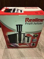 Front and side view of the sealed box featuring Realine fruit juicer and specification images.